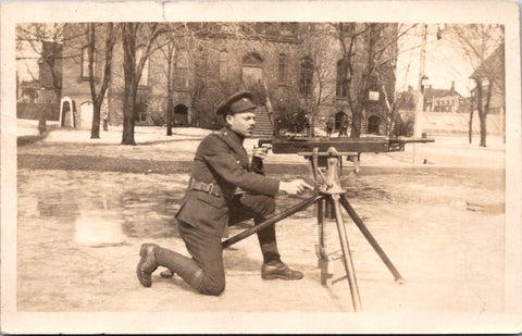 Military - Army Man, firing an automatic rifle on a stand in street, RPPC - QC00