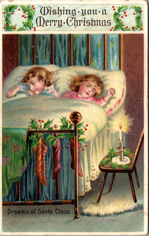 Xmas - Dreams of Santa Claus, 2 kids in bed, stockings hung on brass bed postcar