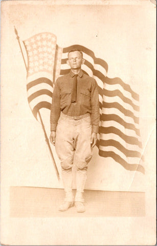 MISC - Military Man in uniform - posing in front of a flowing US flag - RPPC - E23237