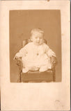 People - Child - sitting on mini stuffed chair with tacks - RPPC - E23245