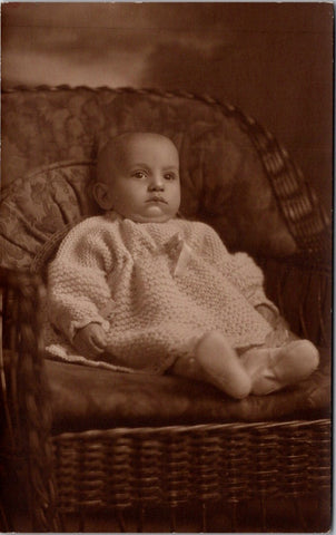 People - Child - sitting in a wicker chair, in knitted outfit - RPPC - F09148