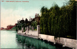 CA, OAKLAND - Lake Merritt w/bldgs, couple sitting at the ledge postcard - I0305