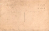 People - Child - sitting in the grass holding an open umbrella RPPC - NL0541