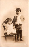 People - Children - posing, 1 in chair 1 standing in thigh boots - KNOX RPPC - NL0890