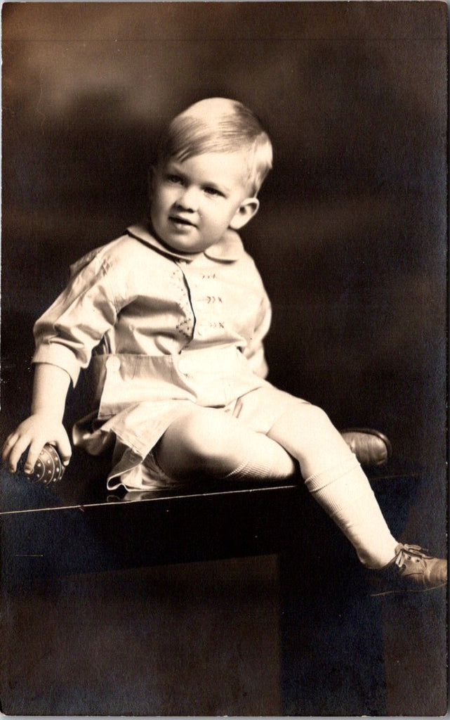 People - Child - sitting - in a white outfit with embroidery - studio RPPC - NL0897