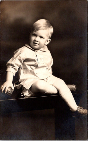 People - Child - sitting - in a white outfit with embroidery - studio RPPC - NL0897