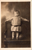 People - Child - standing on carved bench near leather ball - studio RPPC - SH7260