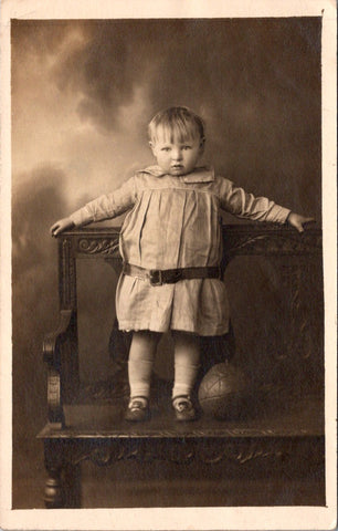 People - Child - standing on carved bench near leather ball - studio RPPC - SH7260