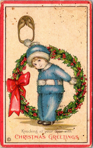 Xmas - kid in blue with a big door knocker in hand and holding a wreath postcard