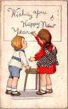New Year - girl writing on board with another child along side - B17129