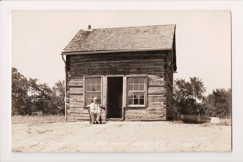 NE, Nebraska City - John Brown Cave, Cabin, Man in chair - RPPC - G17220