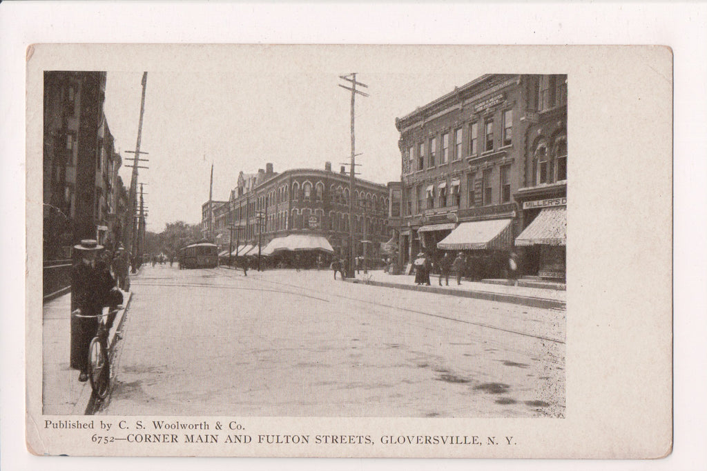 NY, GLOVERSVILLE - Main and Fulton Sts - Millers (store), man on bike - MB0716
